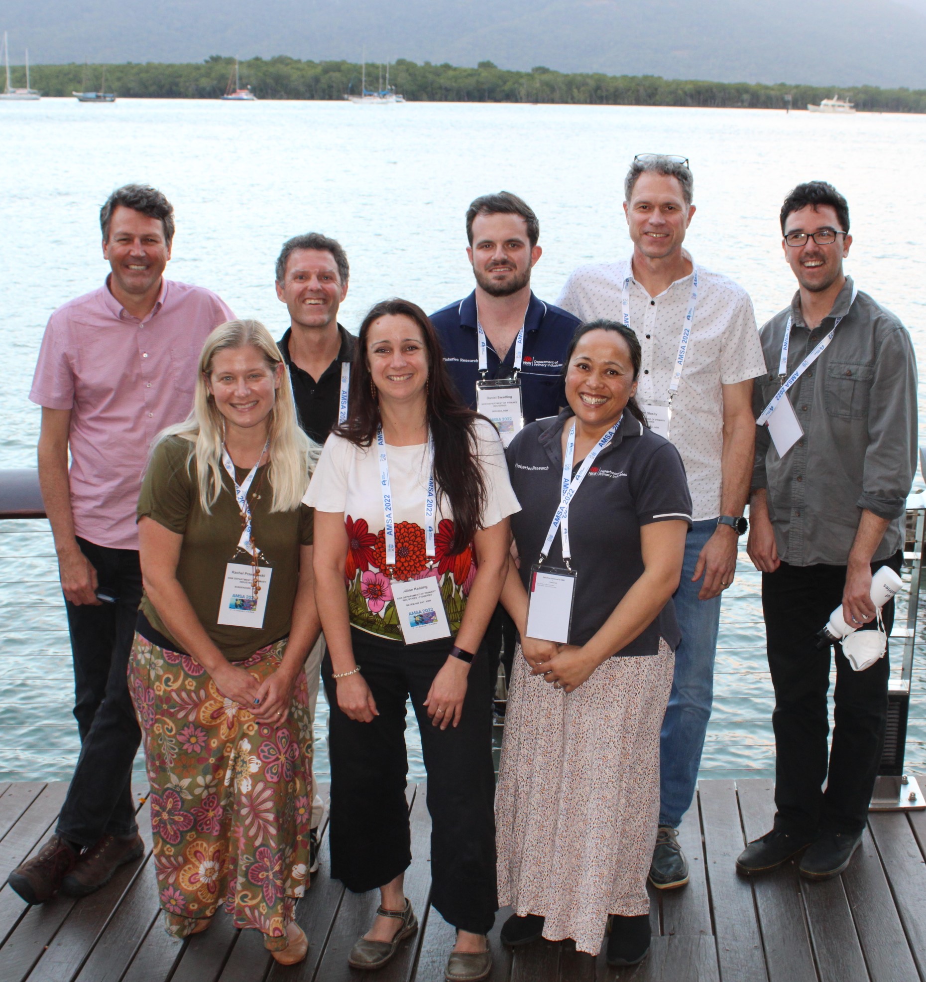 Group of people in front of water all wearing lanyards 