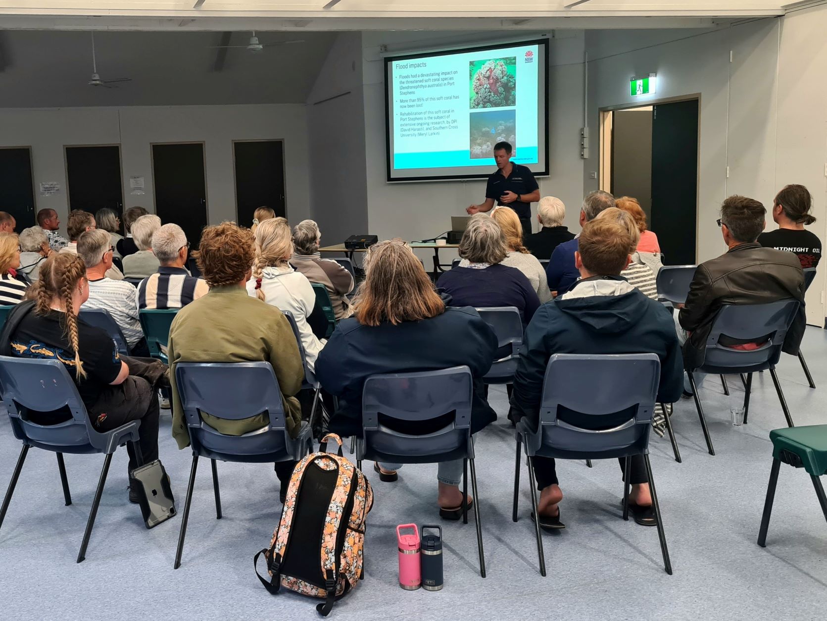 Group of people in a room looking at a presentation 