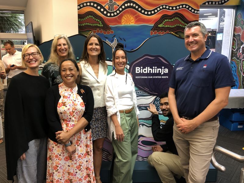 Group of smiling people in front of Museum exhibit 