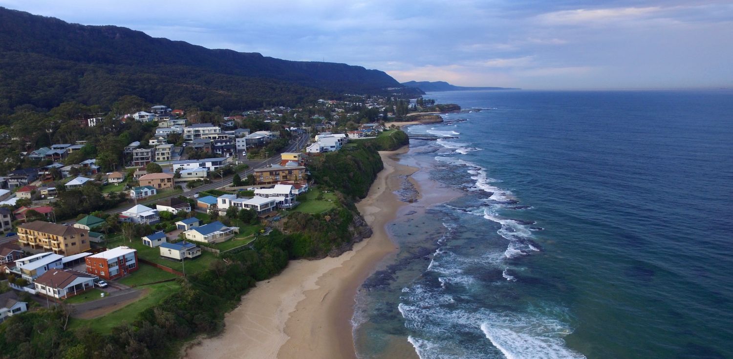 NSW south coast coastline showing ocean, cliffs and houses on headland